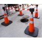 Traffic cone with weighted base and retractable strap